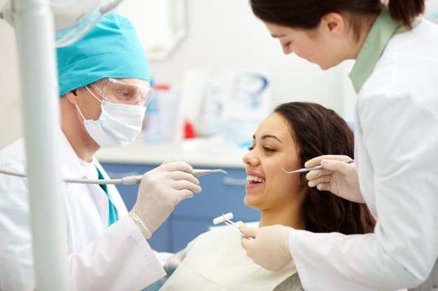dentista-esaminando-denti-di-un-paziente_1098-568