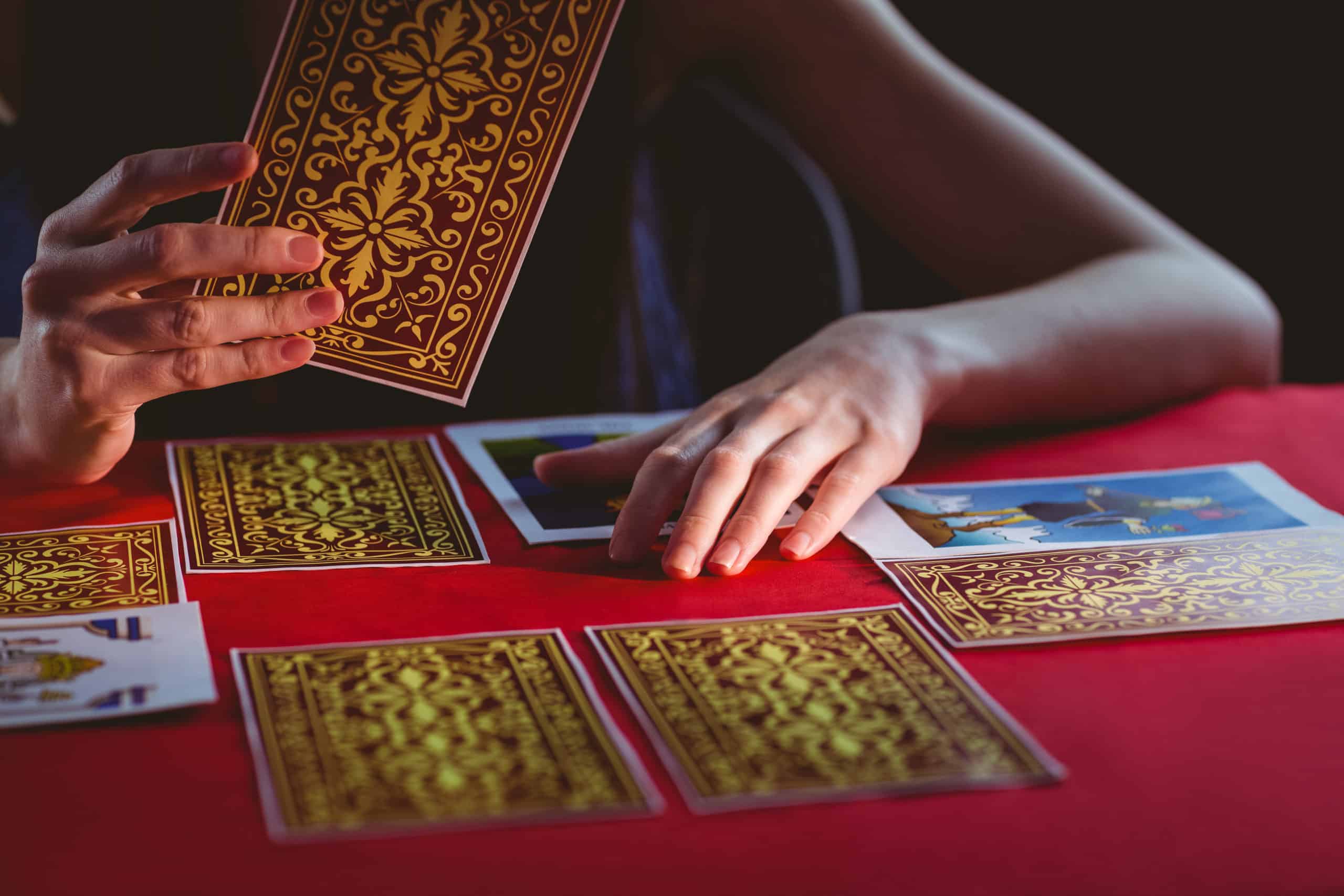 Fortune teller using tarot cards on black background